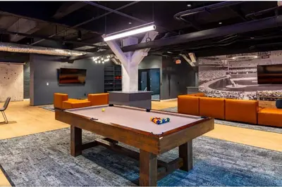 a pool table in a room with orange furniture at Downtown Stroll to the Bengals in Cincinnati