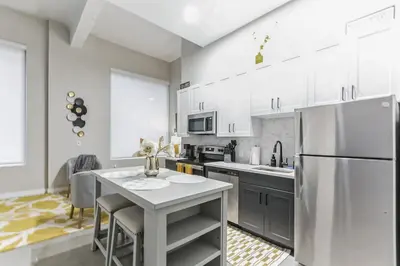 a kitchen with a table and a refrigerator at Downtown Stroll to the Bengals in Cincinnati