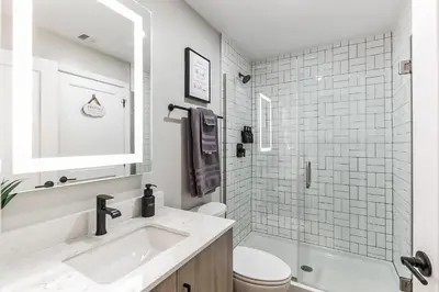 a white bathroom with a sink and a toilet at Downtown Stroll to the Bengals in Cincinnati
