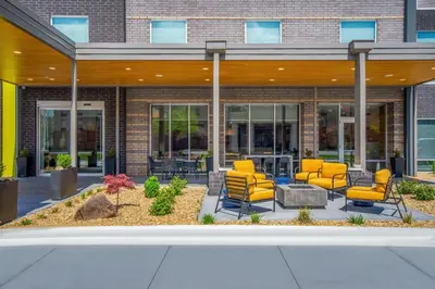 a group of yellow chairs in front of a building at Home2 Suites By Hilton West Chester Cincinnati in West Chester