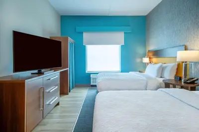 a hotel room with two beds and a flat screen tv at Home2 Suites By Hilton West Chester Cincinnati in West Chester