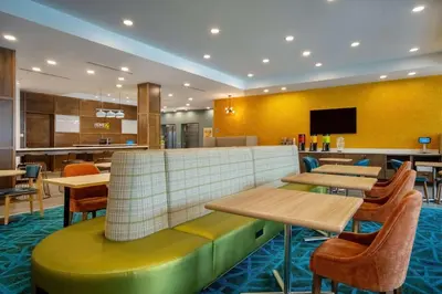 a restaurant with tables and chairs and a tv at Home2 Suites By Hilton West Chester Cincinnati in West Chester