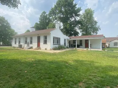 a white house with a grass yard at Birchill Manor in Brookville