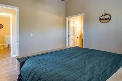 a bedroom with a bed with a blue bedspread at Serene Logan Retreat with Hot Tub and Stargazing Dome in Logan