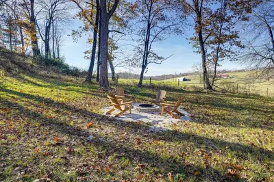 two benches and a fire pit in a field at Serene Logan Retreat with Hot Tub and Stargazing Dome in Logan
