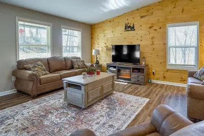 a living room with couches and a flat screen tv at Serene Logan Retreat with Hot Tub and Stargazing Dome in Logan