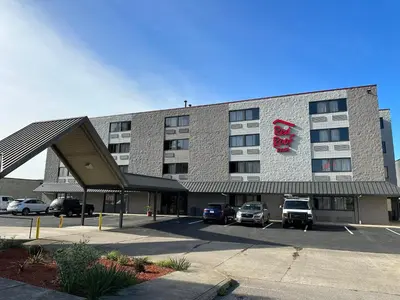 a large building with cars parked in a parking lot at Red Roof Inn Charleston - Dunbar in Dunbar