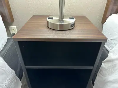 a nightstand with a lamp on it next to two beds at Red Roof Inn Charleston - Dunbar in Dunbar