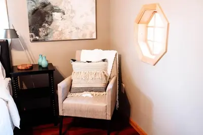 a chair sitting in a room with a mirror at Spacious Five-Bedroom Bliss in Fairlawn