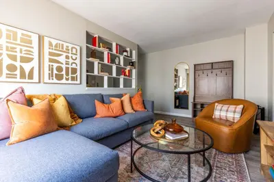 a living room with a blue couch and a table at Maple Heights Oasis - Libby Unit 5 in Maple Heights
