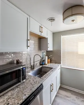 a kitchen with white cabinets and a sink at Maple Heights Oasis - Libby Unit 5 in Maple Heights