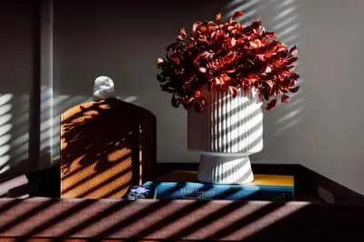 a vase with red flowers sitting on a table at Maple Heights Oasis - Libby Unit 5 in Maple Heights