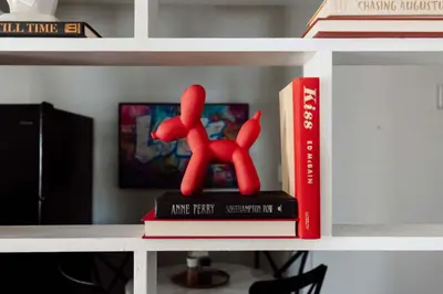 a book shelf with a red figurine on a stack of books at Maple Heights Oasis - Libby Unit 5 in Maple Heights