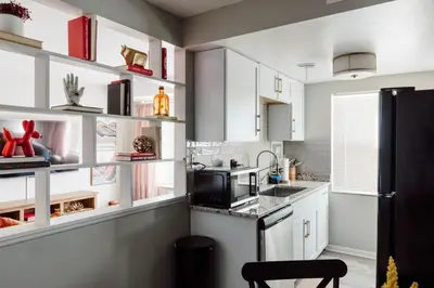 a kitchen with white cabinets and a black refrigerator at Maple Heights Oasis - Libby Unit 5 in Maple Heights