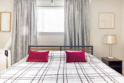 a bedroom with a bed with two red pillows at King & Queen First Floor Unit! 1-2c Georgetown Villas in Fairview Park