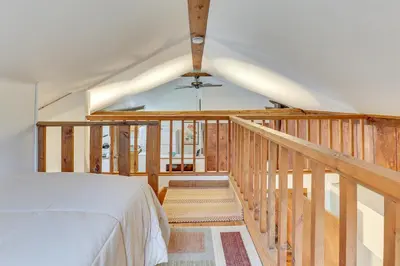 a bedroom with a bed and a staircase with a ceiling at Chagrin Falls Home about 2 Mi to Town! in Chagrin Falls