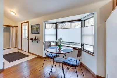 a dining room with a table and chairs and windows at Chagrin Falls Home about 2 Mi to Town! in Chagrin Falls