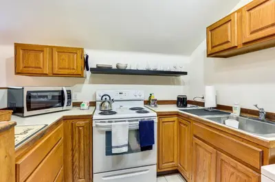a kitchen with wooden cabinets and a white stove top oven at Chagrin Falls Home about 2 Mi to Town! in Chagrin Falls