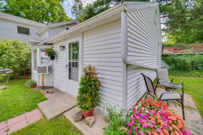 a small white house with a patio and flowers at Chagrin Falls Home about 2 Mi to Town! in Chagrin Falls