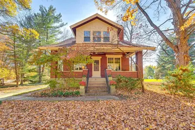 a red house with a tree in front of it at Near Downtown Cincinnati Peaceful Retreat! in Blue Ash