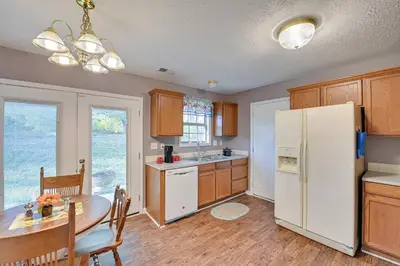 a kitchen with a table and a white refrigerator at Georgetown Home about 6 Mi to Kentucky Horse Park! in Georgetown