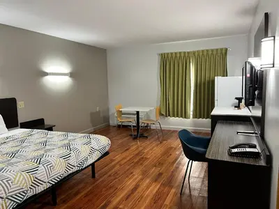 a hotel room with a bed and a table with chairs at Studio 6 Suites Springfield, OH in Springfield