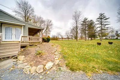 a house with a porch and a grass yard at North Jackson Vacation Rental with Wraparound Deck! in North Jackson