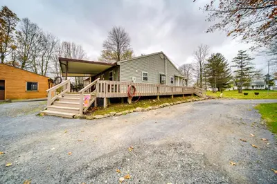 a large house with a porch and a driveway at North Jackson Vacation Rental with Wraparound Deck! in North Jackson