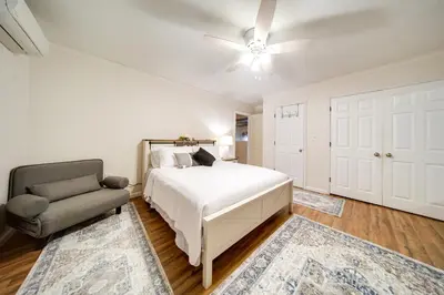 a white bedroom with a bed and a chair at North Jackson Vacation Rental with Wraparound Deck! in North Jackson