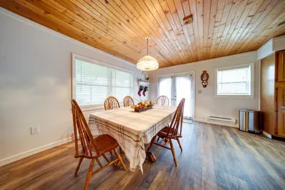 a dining room with a table and wooden ceilings at North Jackson Vacation Rental with Wraparound Deck! in North Jackson
