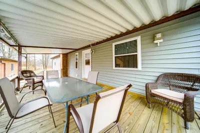 a patio with a table and chairs on a deck at North Jackson Vacation Rental with Wraparound Deck! in North Jackson