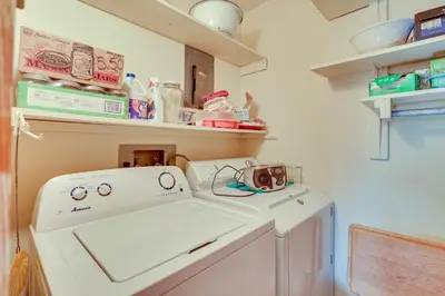 a laundry room with a washing machine and shelves at Family-Friendly Home with Fire Pit about 10 Mi to Akron! in Uniontown