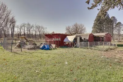 a field with a fence and a barn and a fence at Family-Friendly Home with Fire Pit about 10 Mi to Akron! in Uniontown