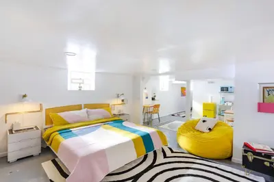 a bedroom with a bed with a yellow and white blanket at Gordon Square Studio about 4 Mi to Downtown Cleveland! in Cleveland