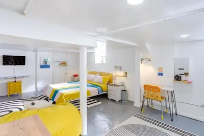 a white room with two beds and a desk at Gordon Square Studio about 4 Mi to Downtown Cleveland! in Cleveland