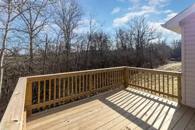 a deck with a wooden railing on a house at Home among the Nook in Hamilton Ohio in Hamilton
