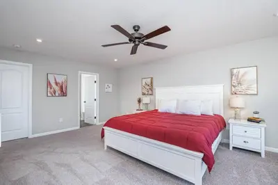 a bedroom with a red bed with a ceiling fan at Cheerful 5 bedroom on azra with a pool and real in Morrow