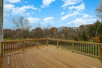 a wooden deck with a view of the woods at Brand new construction in well-kept HOA community in Mason