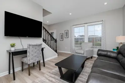 a living room with a couch and a tv at Brand new construction in well-kept HOA community in Mason