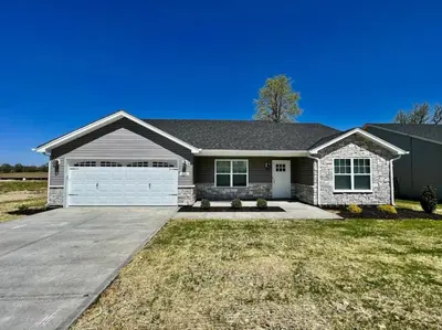 a house with a driveway and a garage at Peaceful, Brand New Ranch Home in Trenton, OH in Trenton