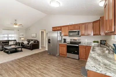 a kitchen and living room with stainless steel appliances at Beautiful NEW Home among the Nook in Hamilton, OH in Hamilton