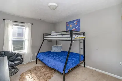 a bedroom with a bunk bed with a blue bed at Relaxing home near Interstate in Monroe