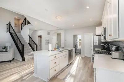 a kitchen with white cabinets and a staircase at Cul de sac home in Family friendly community in Maineville