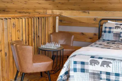 a bedroom with two chairs and a bed and a table at Deerview Cabin by Wanderlust Properties in Logan