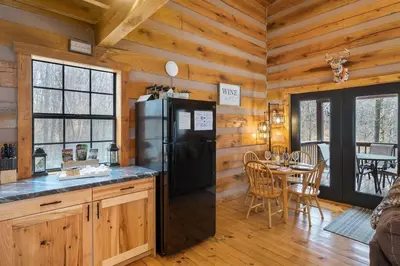 a kitchen and dining room with a refrigerator and a table at Deerview Cabin by Wanderlust Properties in Logan