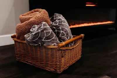 a basket of towels sitting in front of a fireplace at Luxury Cliffside Hammock House in Wellington