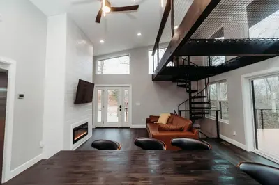 a living room with a table and a fireplace at Luxury Cliffside Hammock House in Wellington