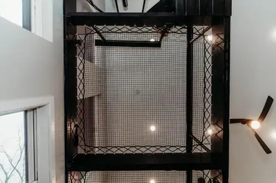 a black cage in a room with a window at Luxury Cliffside Hammock House in Wellington