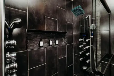 a bathroom with a shower with wine bottles on the wall at Luxury Cliffside Hammock House in Wellington