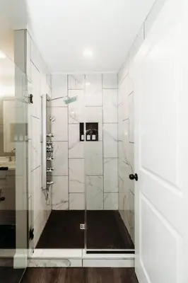a bathroom with a shower with a glass door at Luxury Cliffside Hammock House in Wellington